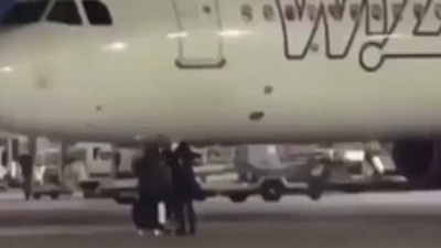 Uçağı kaçıran yolcular acil durum butonuna basarak piste koştu (Video)